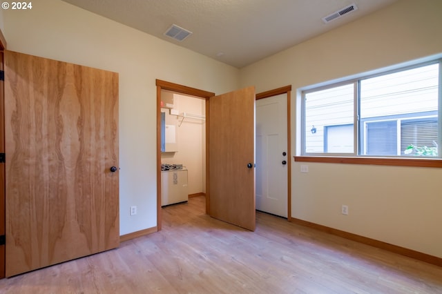 unfurnished bedroom featuring light hardwood / wood-style floors and a closet