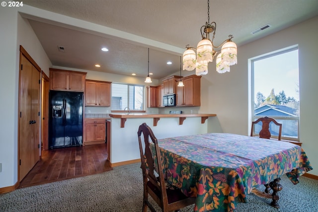 dining room with dark hardwood / wood-style flooring, sink, and an inviting chandelier