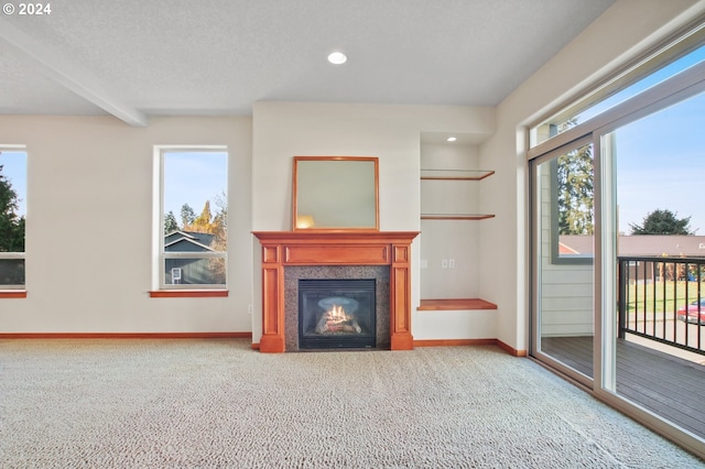 unfurnished living room with carpet flooring, a textured ceiling, and beamed ceiling