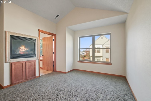 unfurnished living room with light carpet and vaulted ceiling