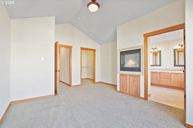 511 NE 84th Cir, Vancouver, WA 98665 - unfurnished bedroom featuring light carpet, lofted ceiling, baseboards, ensuite bath, and a walk in closet