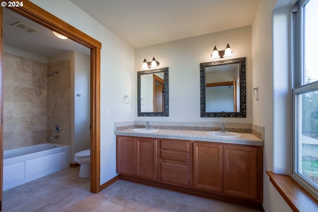 full bathroom with vanity, toilet, and tiled shower / bath