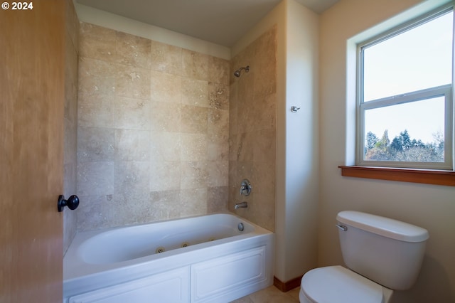 bathroom featuring toilet and tiled shower / bath