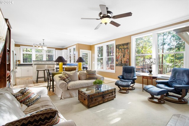 carpeted living room featuring crown molding, ceiling fan, and a wealth of natural light