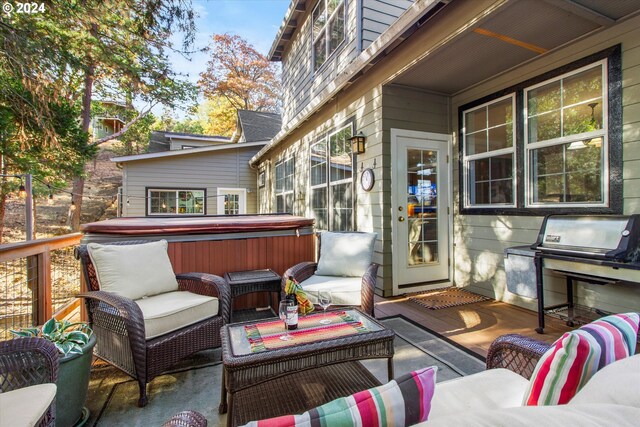 wooden terrace with a hot tub, an outdoor living space, and a patio area