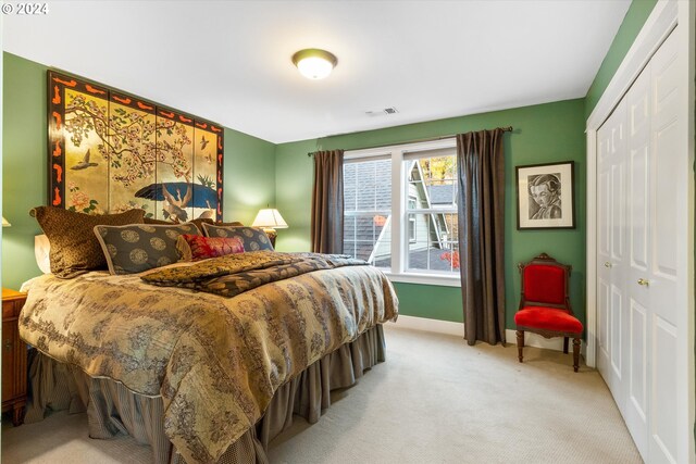 bedroom featuring light colored carpet and a closet