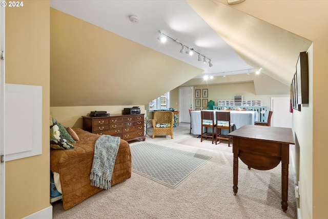 bedroom with carpet floors, rail lighting, and lofted ceiling