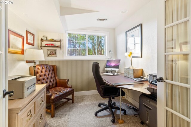 carpeted home office with lofted ceiling