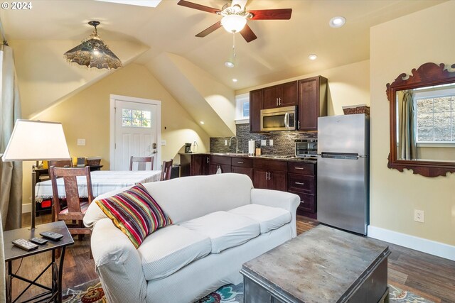 living room with dark wood-type flooring, a healthy amount of sunlight, lofted ceiling, and sink