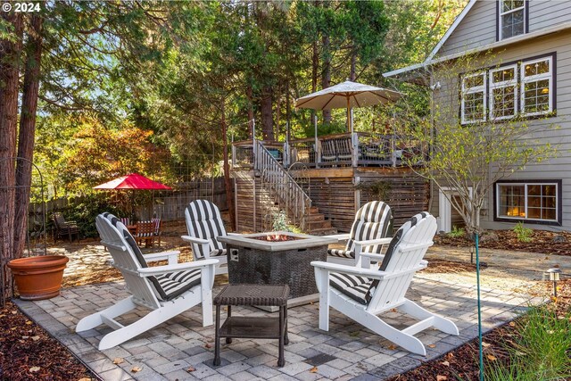 view of patio / terrace with a wooden deck and an outdoor fire pit