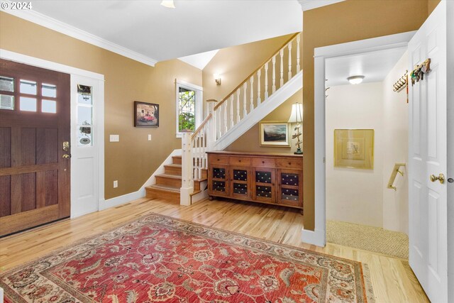 foyer entrance featuring ornamental molding and light wood-type flooring