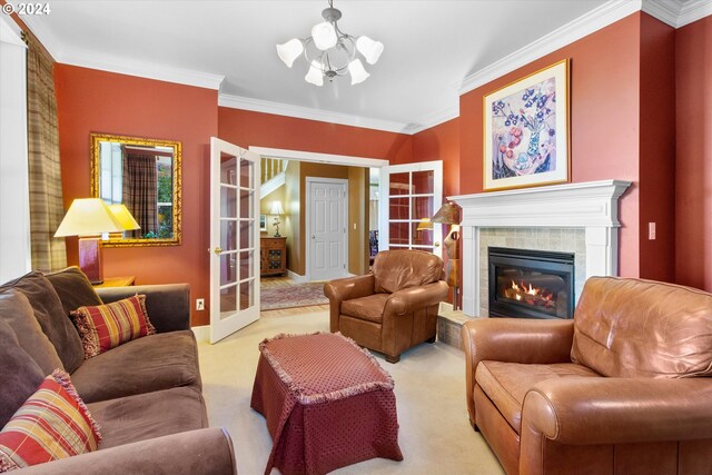 carpeted living room featuring french doors, ornamental molding, a tiled fireplace, and a chandelier