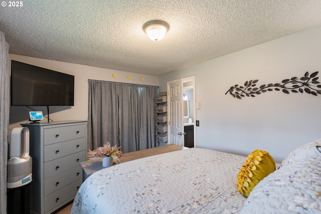 bedroom featuring a textured ceiling and ensuite bath