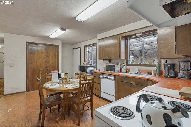 kitchen with a textured ceiling, sink, and white appliances