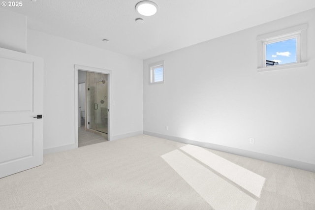 unfurnished bedroom with baseboards, ensuite bath, and carpet flooring