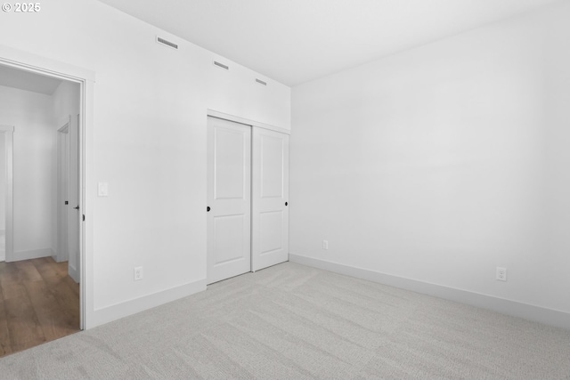 unfurnished bedroom featuring a closet, baseboards, visible vents, and carpet flooring