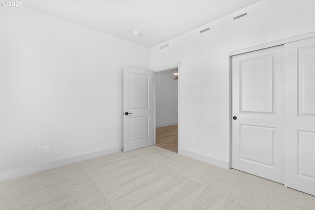 unfurnished bedroom featuring a closet, visible vents, carpet flooring, and baseboards