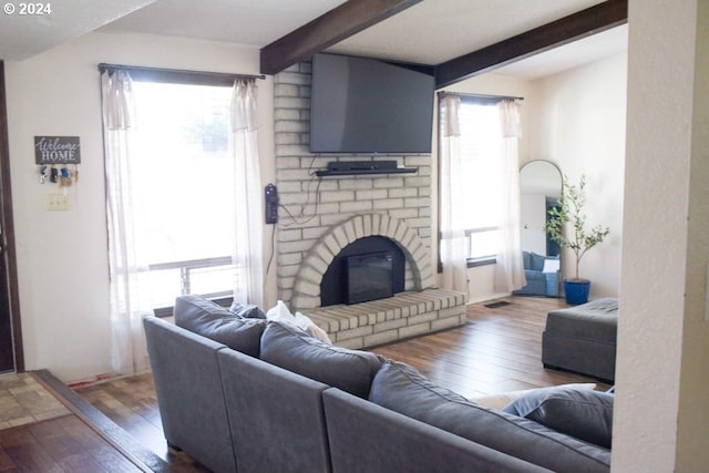 living room featuring a fireplace, beamed ceiling, and dark hardwood / wood-style floors