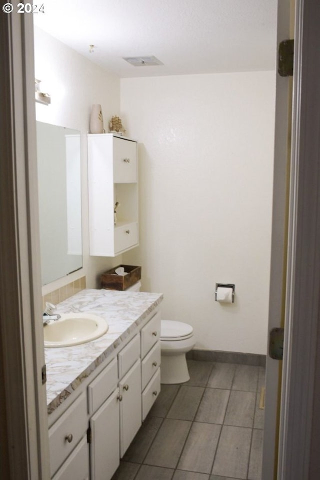 bathroom featuring toilet, vanity, and tile patterned floors