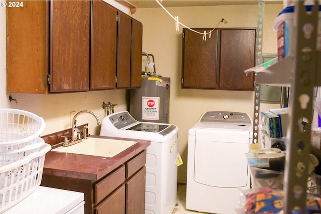 laundry room with sink, water heater, washer and clothes dryer, and cabinets