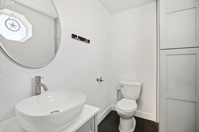 bathroom with hardwood / wood-style floors, vanity, and toilet