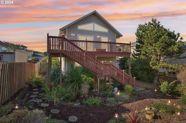 back house at dusk with a deck