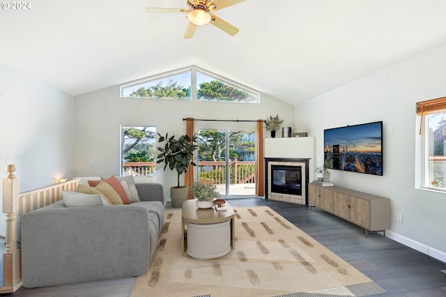 living room featuring a tile fireplace, ceiling fan, dark wood-type flooring, and lofted ceiling