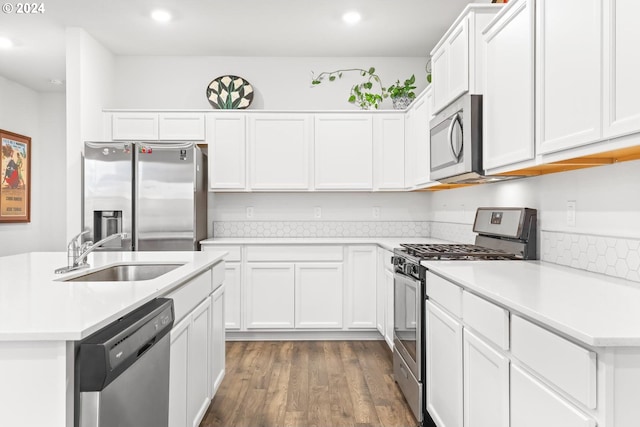 kitchen with white cabinets, stainless steel appliances, sink, and dark hardwood / wood-style floors