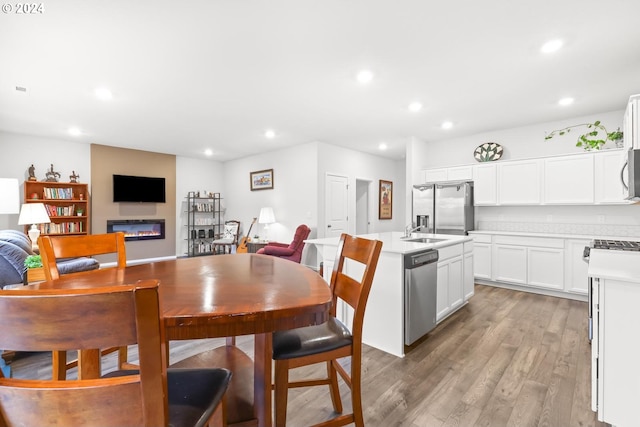 dining space with sink and light hardwood / wood-style flooring