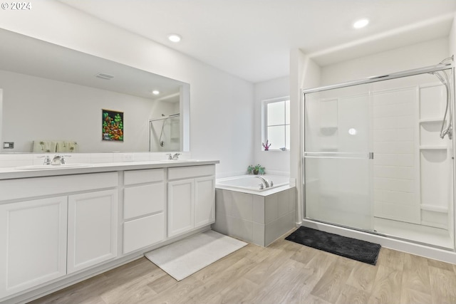 bathroom featuring vanity, plus walk in shower, and wood-type flooring