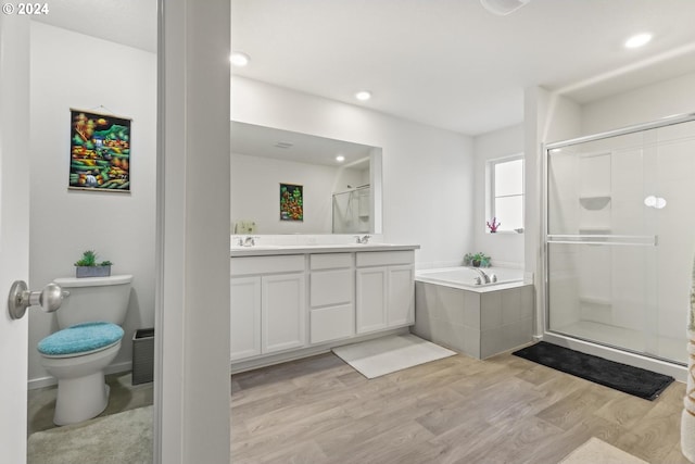 full bathroom with toilet, independent shower and bath, vanity, and hardwood / wood-style flooring