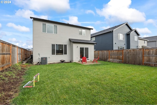 rear view of house with central AC unit, a yard, and a patio