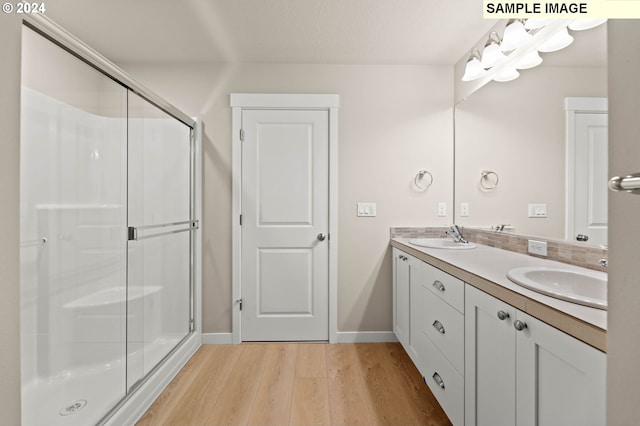 bathroom featuring vanity, hardwood / wood-style flooring, and a shower with door