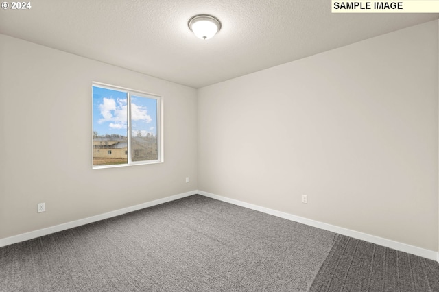 carpeted empty room with a textured ceiling