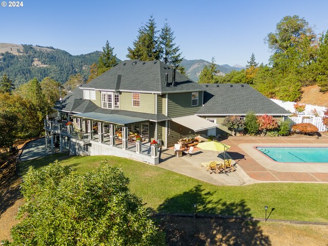 317 Aker Dr, Myrtle Creek, OR 97457 - rear view of property with a patio area, a mountain view, an outdoor pool, and roof with shingles