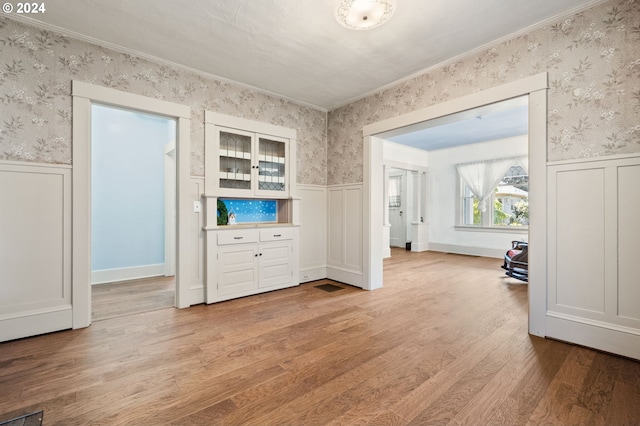 unfurnished bedroom with light wood-type flooring and ornamental molding