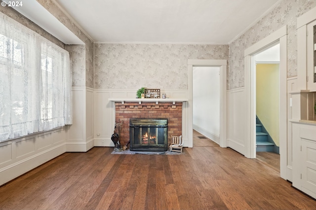 unfurnished living room with hardwood / wood-style flooring, a fireplace, and crown molding