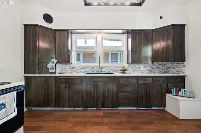 kitchen featuring dark wood-type flooring, sink, range with electric cooktop, decorative backsplash, and dark brown cabinetry