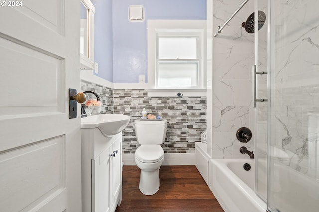 full bathroom featuring vanity, tiled shower / bath combo, wood-type flooring, tile walls, and toilet