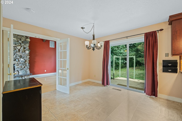 unfurnished dining area with french doors, a notable chandelier, and light tile patterned flooring