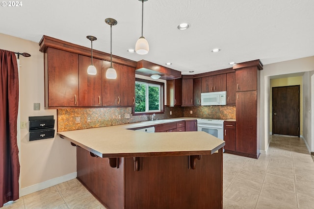 kitchen featuring kitchen peninsula, a kitchen breakfast bar, decorative light fixtures, and white appliances