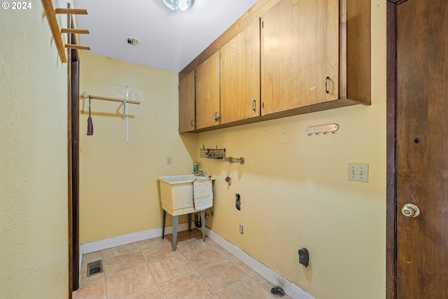 laundry room featuring cabinets and light tile patterned flooring