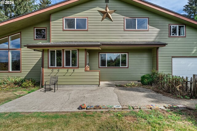 back of house featuring a garage and a patio area