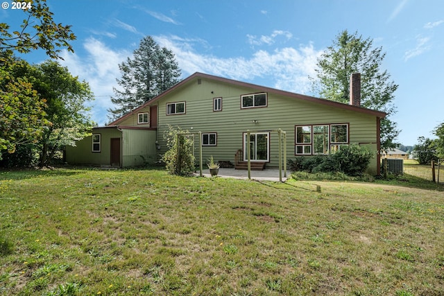 back of property with a yard, a patio, and central air condition unit