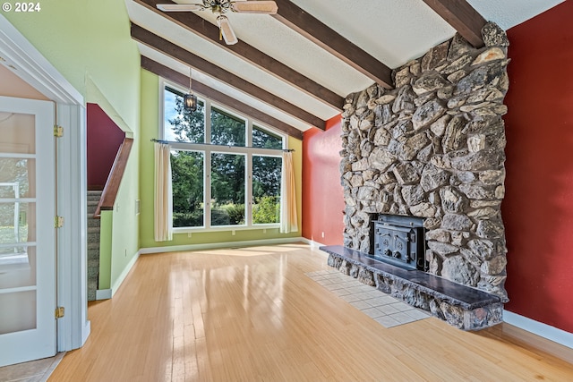 unfurnished living room featuring light hardwood / wood-style flooring, beamed ceiling, and a fireplace