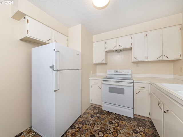 kitchen with white appliances, white cabinets, and a textured ceiling