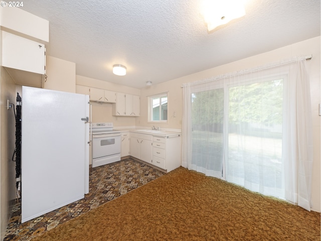 kitchen featuring sink, white appliances, white cabinetry, and a textured ceiling