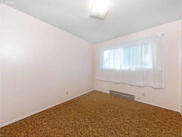 spare room featuring vaulted ceiling, carpet, and a baseboard radiator