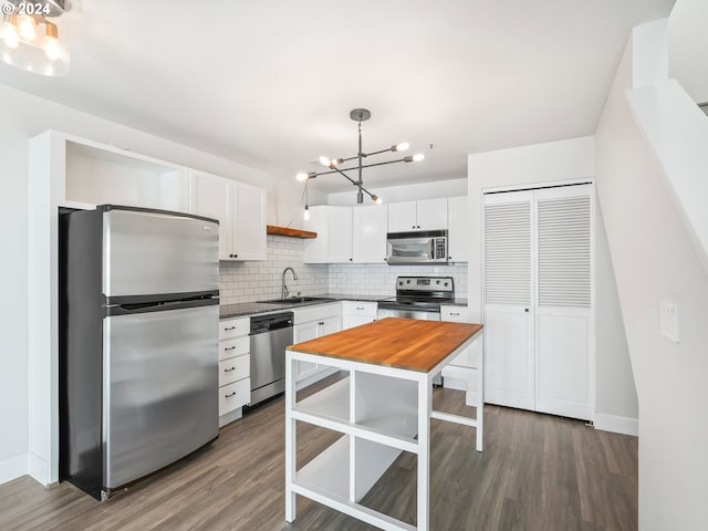 kitchen with sink, decorative backsplash, decorative light fixtures, white cabinetry, and stainless steel appliances