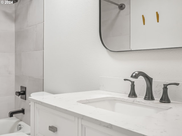 bathroom featuring vanity and tiled shower / bath